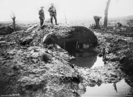 Canadian soldiers standing on a waterlogged German pillbox at Passchendaele
