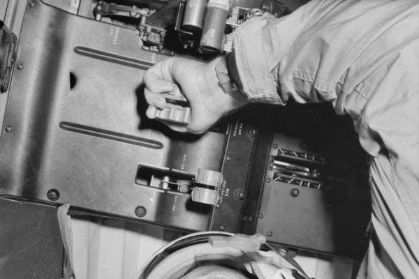Operating propeller pitch controls aboard a Caribou aircraft during flight, June 1965