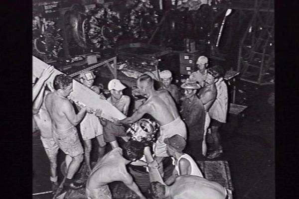 RAAF fitters and South Vietnamese civilians lifting an aircraft propeller after servicing, Vung