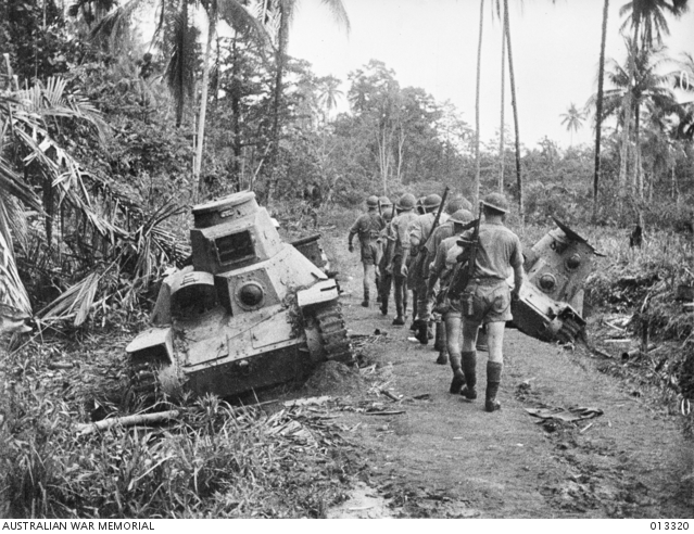 Infantry marching past a tank at Milne Bay