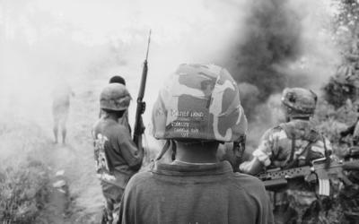 A smoke grenade goes off as armed members of the Bougainville Resistance Force (BRF) patrol with soldiers from the Papua New Guinea Defence Force (PNGDF) in the Nagovis district, southwest Bougainville, during the civil war