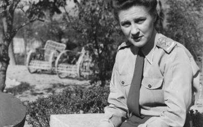 Captain (Capt) Perditta M McCarthy of the Royal Australian Army Nursing Service (RAANS) is seated in a garden with a notebook or diary in her hands