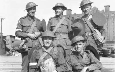 Group portrait of officers of Signals units of the 9th Division awaiting ferry transport to the troop transport 'Queen Mary' for embarkation prior to leaving for the Middle East.