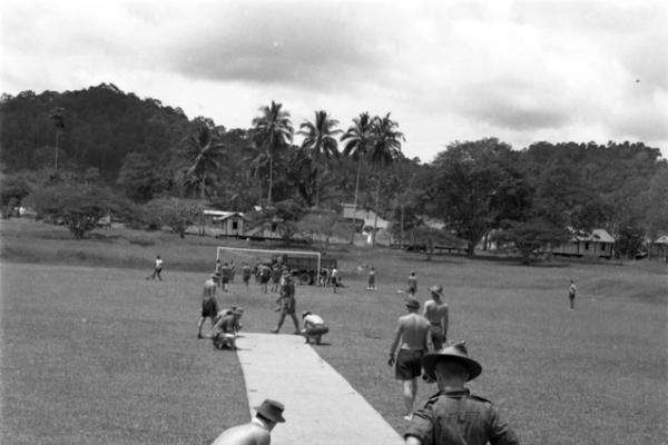 The Malayan Emergency (1948-1960): After more than a week of “jungle bashing”, men of B Company, 2nd Battalion, Royal Australian Regiment (2RAR), at their base camp in Kroh prepare a ground sheet pitch for a game of cricket.