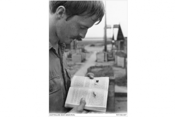Second Lieutenant Graham David Spinkston with the book in Vietnam.