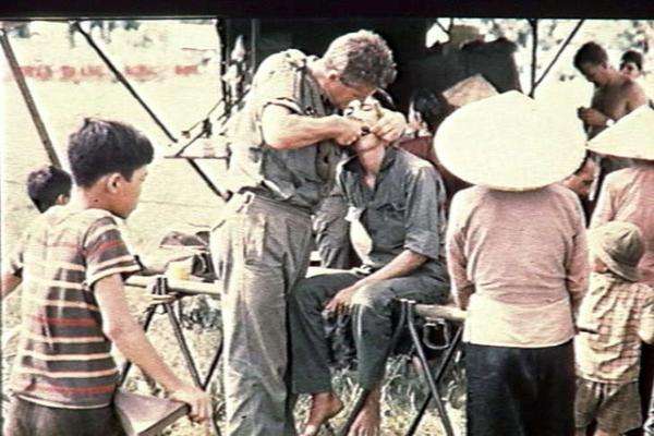 Australian Army doctor performing a dental extraction for a Vietnamese patient, Binh Gia, 1967