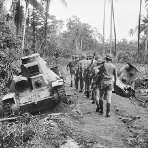 An Australian infantry section pass – Japanese type 95 ha-go light tanks knocked out at Milne Bay