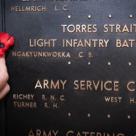 Australian War Memorial Indigenous Liaison Officer Michael Bell places a poppy beside the name of Private Ngakyunkwokka on the Roll of Honour. AWM25.PR051