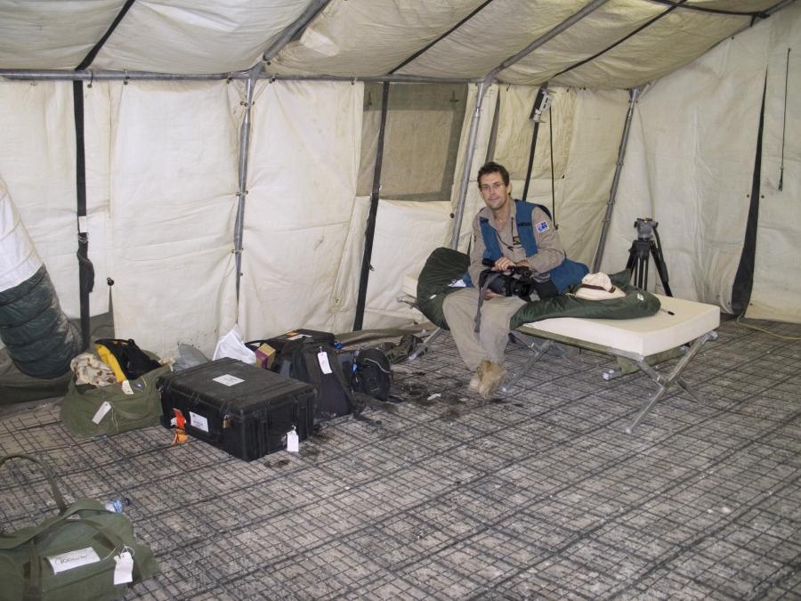 The first official cinematographer, Robert Nugent, with his equipment inside his accommodation at Camp Smitty, Iraq, 2006. (AWM P05512.017)