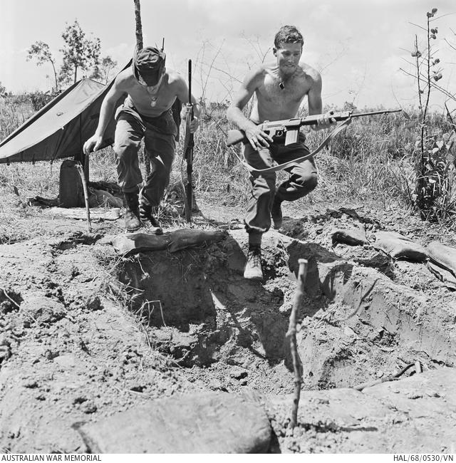 Private Gary Franklin (left) and Lance Corporal Warren Alloway of Australian Task Force headquarters leap into their half-dug weapon pit for cover during an enemy alert at FSB Coral, May 1968.