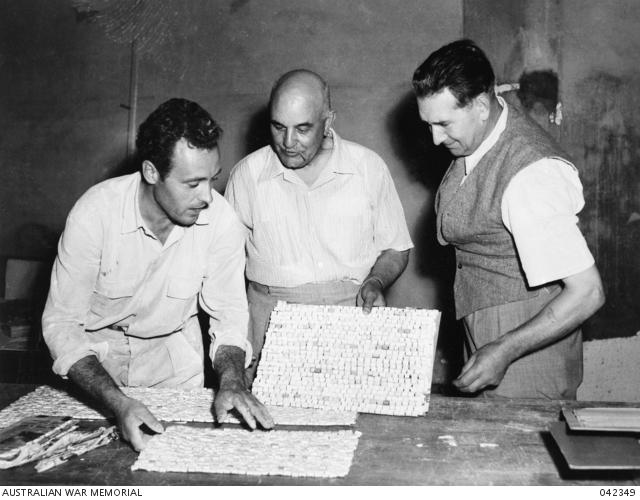 Aldo Rossi (left), Severino De Marco (centre) and Napier Waller, examining the mosaic prior to the first fixing, in the Hall of Memory at the Australian War Memorial. 
