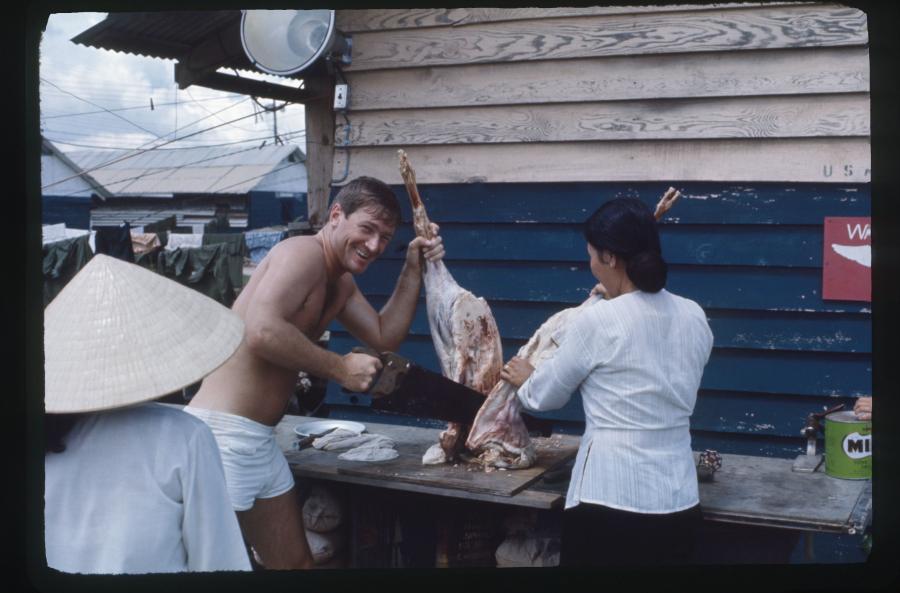 Ken Semmler with Mammasan Oke holding the leg of mutton with her assistant Miss Hi looking on. 
