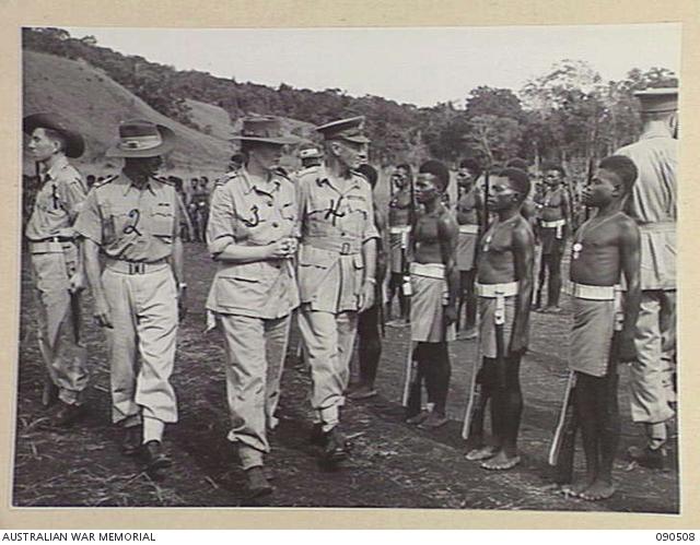 Near Nadzab, New Guinea, March 1945. Lady Wakehurst (3), accompanied by Lieutenant General V.A.H Sturdee (4), inspecting C Company, 2 New Guinea Infantry Battalion at Camp Diddy. Identified personnel are: Sergeant Don Collins (1) and Major W.L. Darcey, Brigade Major, Pacific Islands Regiment (2).