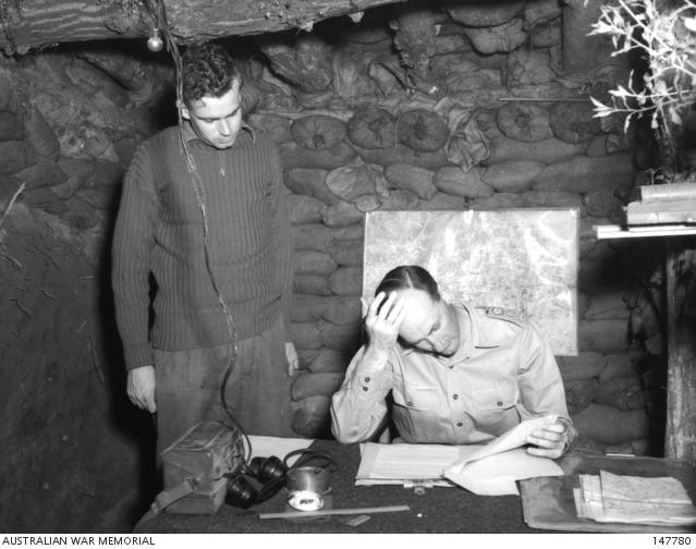 Lt Col Frank Hassett studying a paper given to him by Captain Lee Greville.