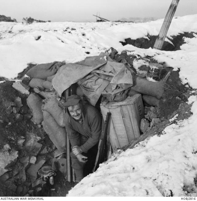 Korea. c January 1952. A soldier leaving his snow covered dug-out in the 3rd Battalion, The Royal Australian Regiment (3RAR), position in Korea. 