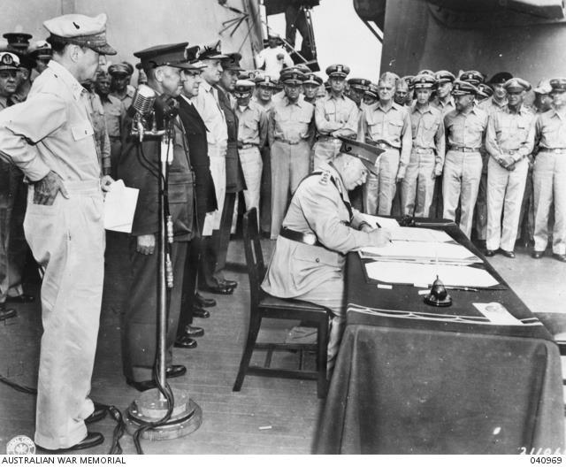 General Sir Thomas Blamey signs the surrender on behalf of Australia as General Douglas MacArthur looks on, Tokyo Bay, 2 September 1945.