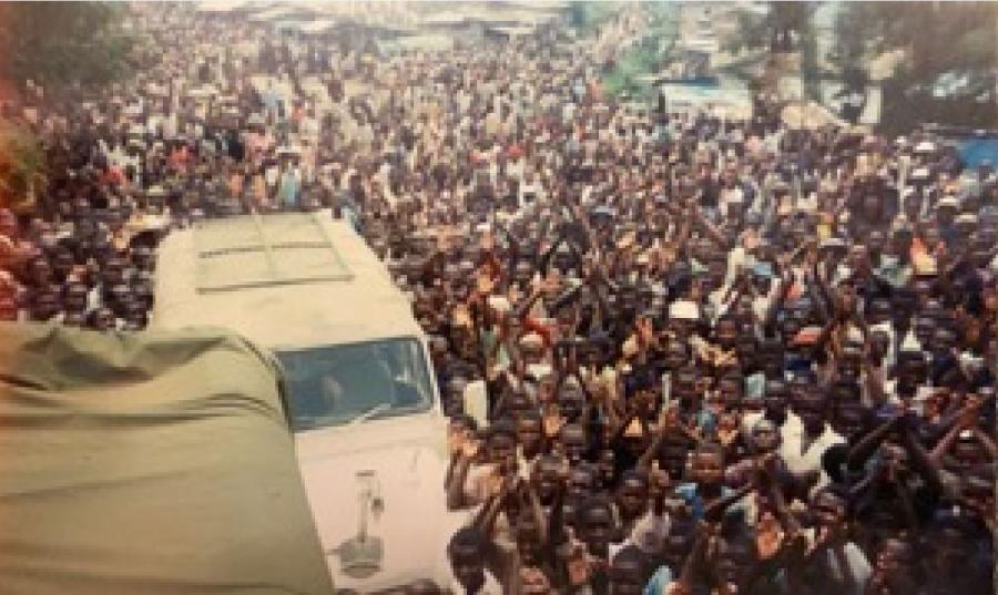 Crowds of people gather around the trucks in Rwanda