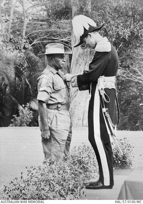 Corporal Charles Mene receives the Military Medal from Sir Douglas MacGillivray, British High Commissioner to Malaysia, 5 June 1957 HAL/57/0100/MC