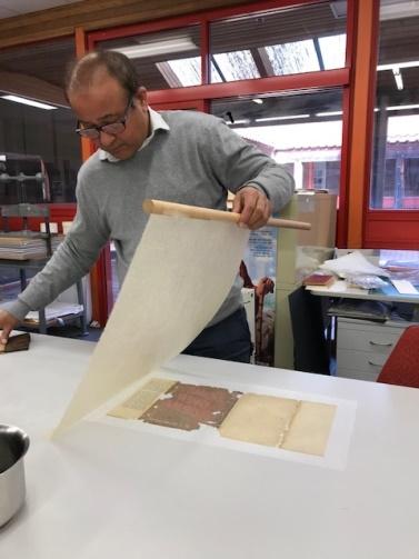 Japanese paper being laid onto the back of the Jacket cover and pasted down