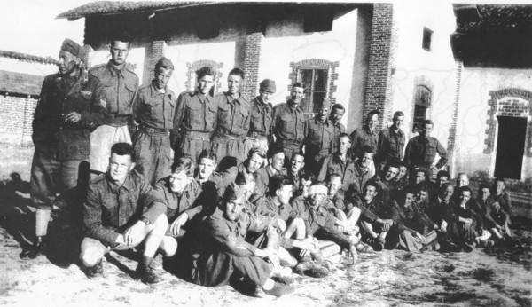 Australian and NZ POWs at a Camp 106 work farm with an Italian Guard (L) 1943.  (Photo: aifpow.com)