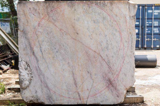 The red, orange and pink markings on the outside of the marble guide the artist’s selection of the block. 