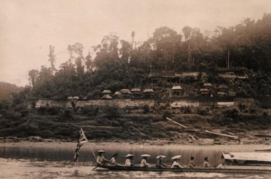 A canoe full of Semut guerrillas, flying the Union Jack, advancing down the Baram River to mount an attack against the Japanese.
