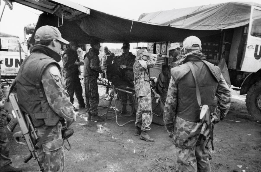 Medical personnel of the Australian Medical Support Force (AMSF) treating a wounded refugee