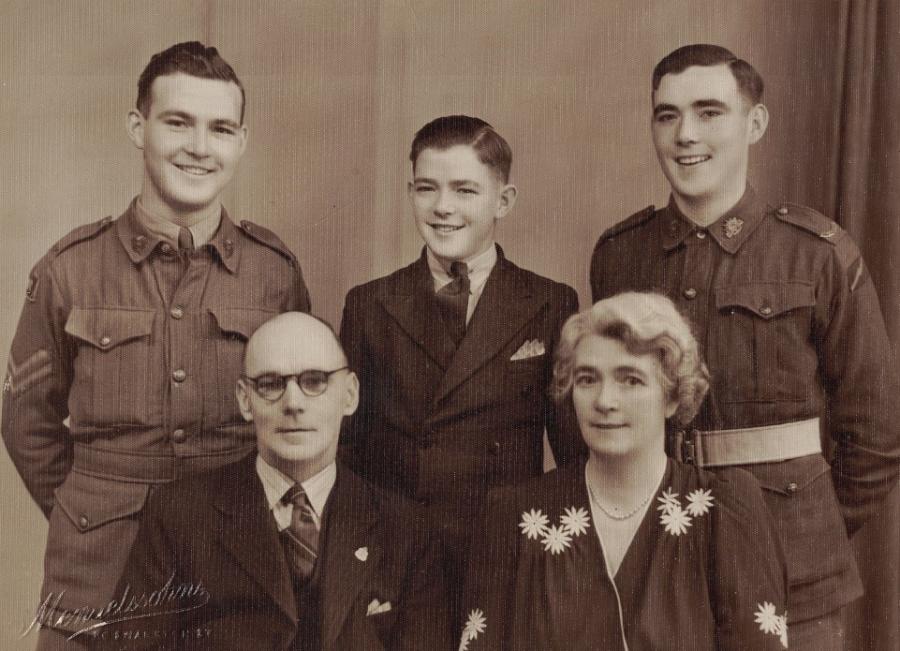 Ken Goodliffe (left) posing in uniform for a photo with his family.