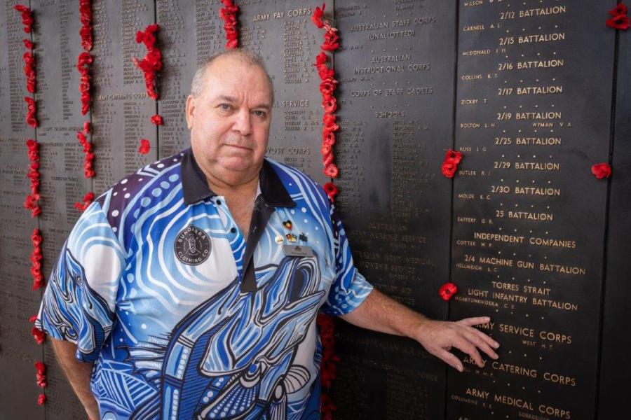 Australian War Memorial Indigenous Liaison Officer Michael Bell places a poppy beside the name of Private Ngakyunkwokka on the Roll of Honour. AWM25.PR051