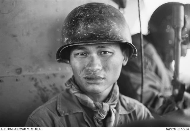A member of the 9th Army Republic of Vietnam sits in an Iroquois helicopter, ready to be inserted into a search area.
