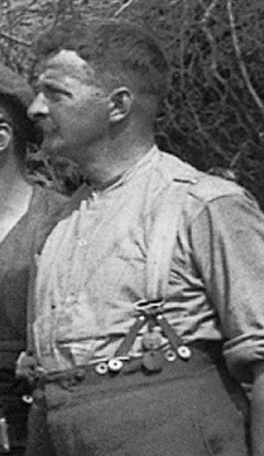 An artilleryman in his shirt and breeches wears his two identity discs hanging from his suspenders.