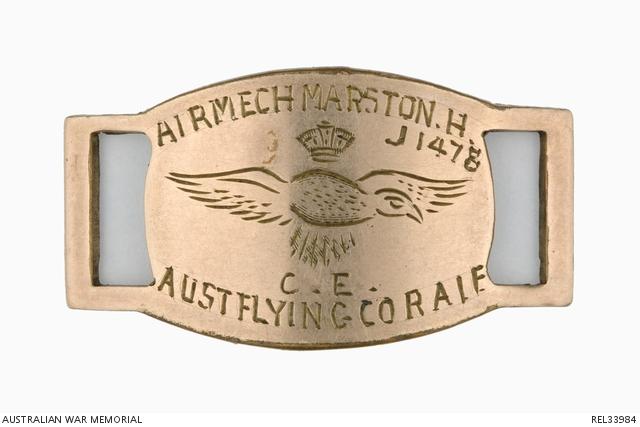 Identity bracelet disc worn by Aircraft Mechanic Henry Marston. It is made from brass and features an engraved eagle and crown in the centre with his details engraved above and below the bird.