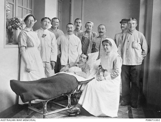 Nurse Claire Trestrail (seated) with patients and a ward assistant at Antwerp, 1914. R Guilleminot, P08673.002
