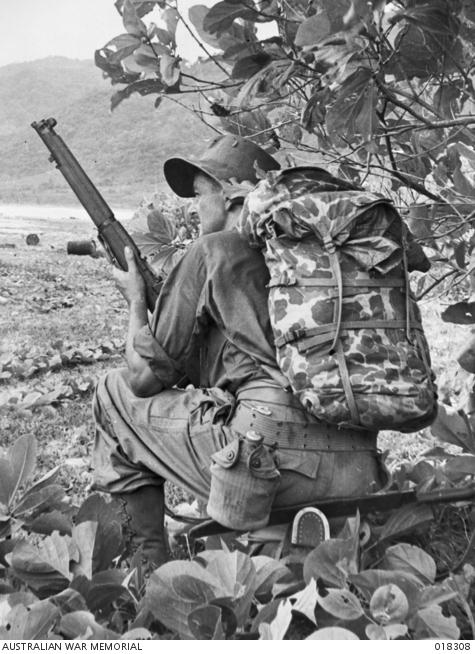 "John Scarlett, War Correspondent for the Sydney Morning Herald and Melbourne Age, poses in American equipment at the But Jetty area."