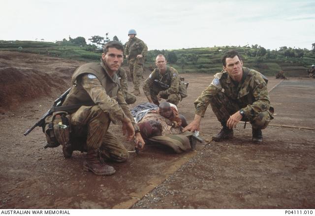 "George Gittoes, Four Australian infantry soldiers assist a Rwandan mother and her child following the massacre at the Kibeho refugee camp, April 1995 P04111.010"