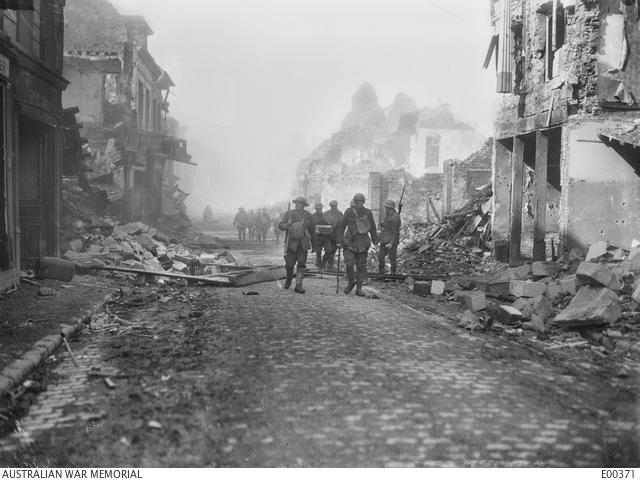 "Herbert Baldwin, Australians making their way along a street of burning ruins, Bapaume, 1917 E00371"