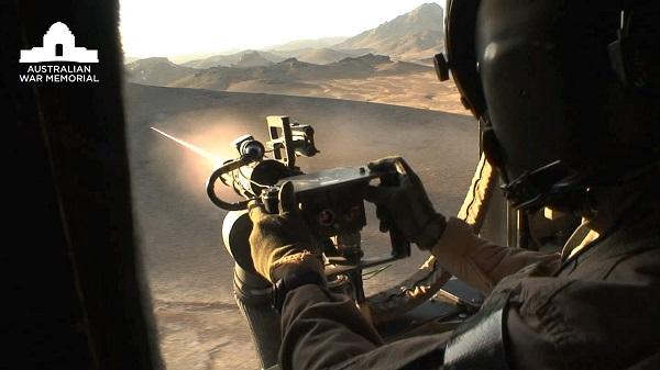 Gunner of Australian Army CH-47D Chinook medium lift helicopter fires his 6-barrel M134 Dillan mini-gun during a resupply missio