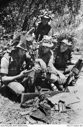 South Vietnam. May 1971. Captain Terry Properjohn of Tas (centre), and two members of the Jungle Warfare Training Centre (JWTC) patrol, examine weapons and documents they captured after contact with the Viet Cong (VC), west of the 1st Australian Task Forc