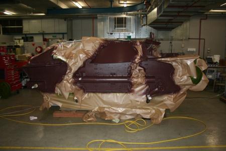 Green camouflage masked off to expose areas to be painted mahogany brown