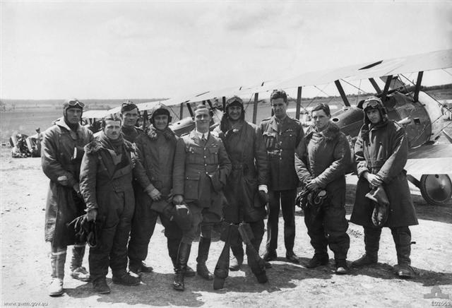 The officers of A Flight, No. 4 Squadron, Australian Flying Corps (AFC), in full flying gear in front of line up of Sopwith Camel aircraft.