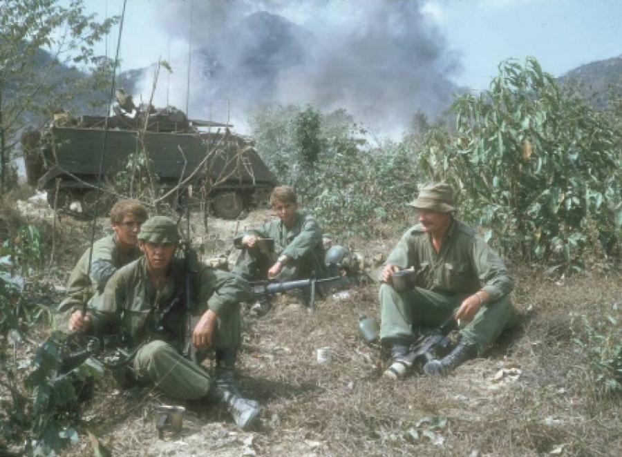 When C Company 8RAR took a break, the attached New Zealand artillery forward observer party made a brew. From left to right, Gunners Wayne Radavanovich, Michael “Brutus” Brunton, Rodney Simpson and Lieutenant Angus Rivers surround a liberated tin of condensed milk found in an enemy cache. The milk had come from New Zealand and the Kiwis wasted no time in using it. Photo: Rod Simpson. 