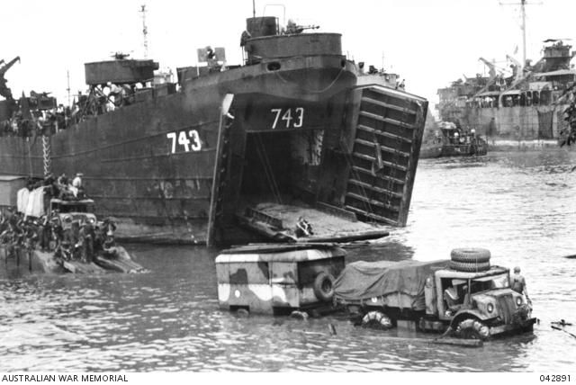 Tarakan, Borneo. 1945-05. Trucks coming off the Landing Ship, Tanks became bogged in the soft sand during the landing by the 9th Division AIF and RAAF units.