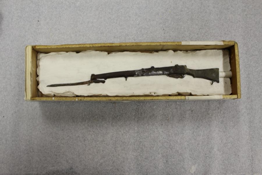 Box built around modelling clay and rifle
