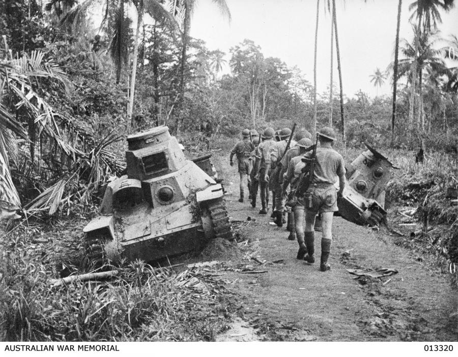 1942-10-01. New Guinea. Milne Bay. An Australian infantry section pass - Japanese type 95 ha-go light tanks knocked out at Milne Bay.