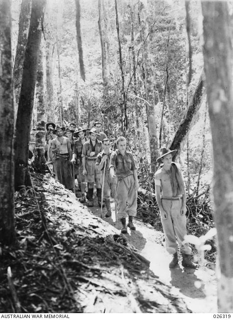 Wounded members of the 39th Infantry Battalion making their way along a jungle trail to the base hospital, a journey of six days by foot. All are suffering gunshot wounds sustained in fighting against Japanese forces in the Kokoda area.