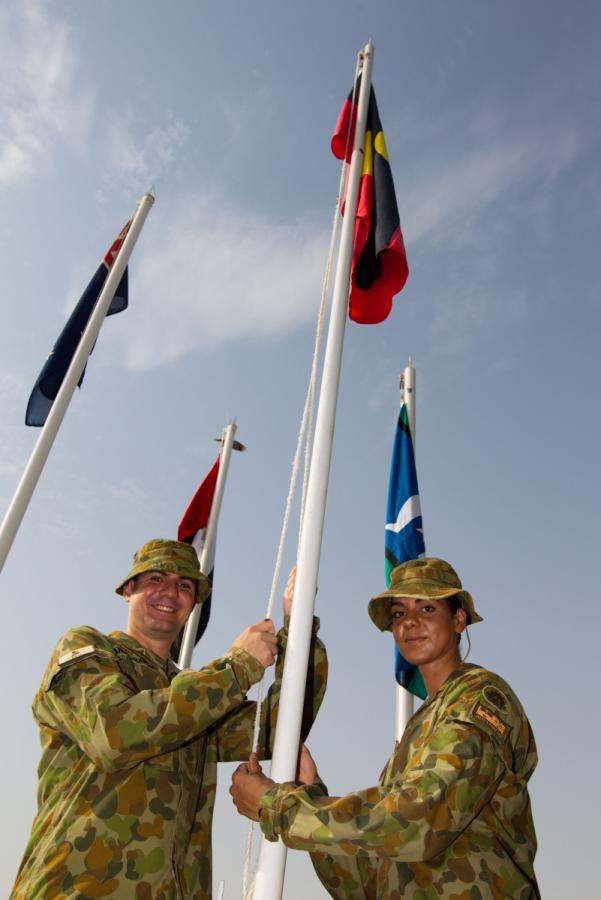 Sergeant John Angel-Hands and Lance Corporal Natalie Whyte raise the Aboriginal and Torres Strait Islander flags at Al-Minhad air base, United Arab Emirates, July 2013 courtesy Commonwealth of Australia, Department of Defence Joel Graham