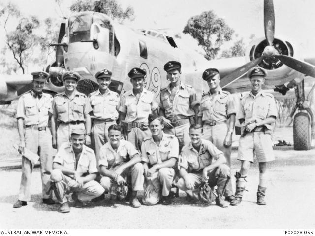 Group portrait of members of the RAAF standing in front of a Liberator aircraft, 99.