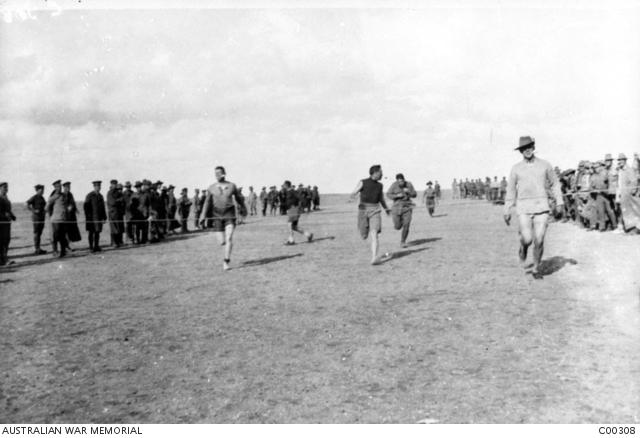 Competitors approach the finishing line during the egg and spoon race at an Anzac Day sports 