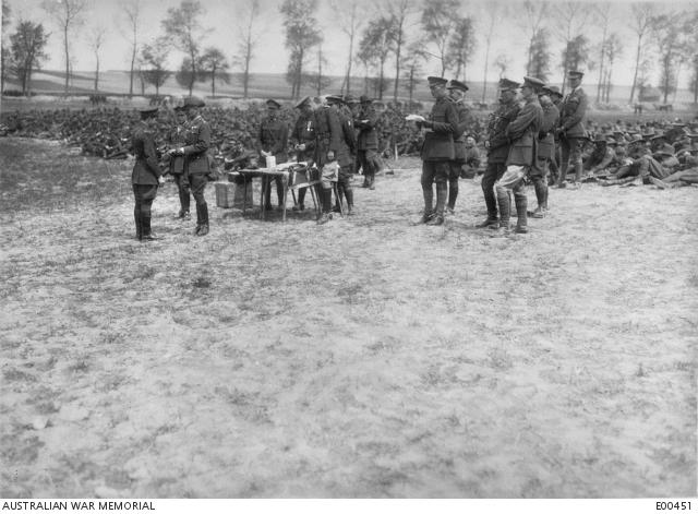 General Sir William Riddell Birdwood decorating an officer for bravery in the first attack on the Hindenburg Line. The ceremony took place at Ribemont. Major Charles Melbourne Johnston DSO, 15th Battalion, stands on the far right up the back. C.E.W. Bean, Australian Official Correspondent, is a few rows in front of him wearing light coloured pants.