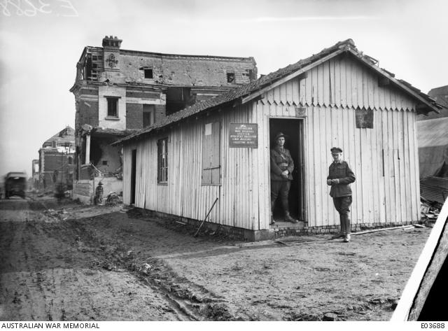Black and white photograph of two men standing outside of a building